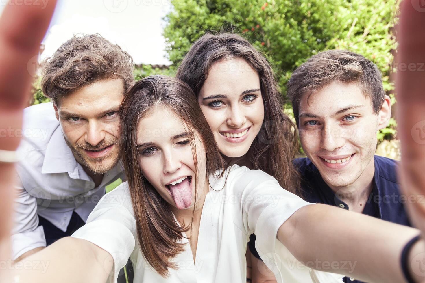 grupo de joven personas tomar un selfie abrazado juntos foto