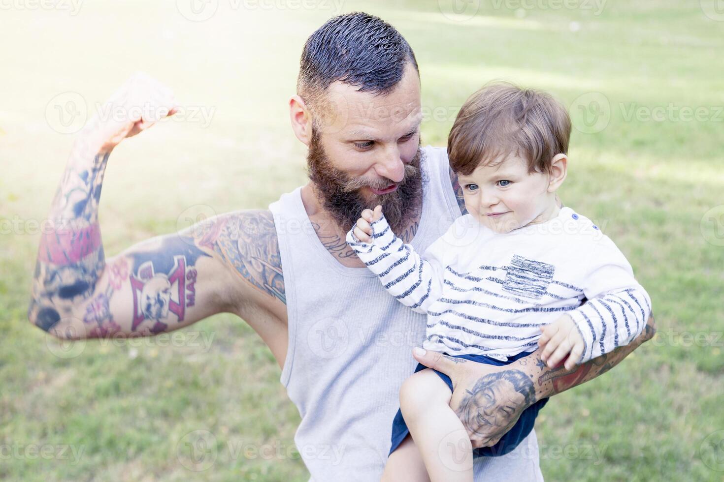 tatuado padre tener divertido con su hijo en el parque foto