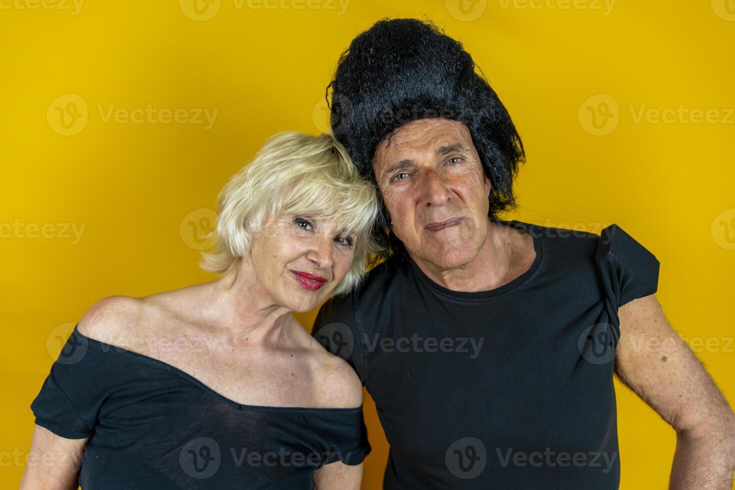 attractive elderly couple dressed in 50's style isolated on colorful background photo