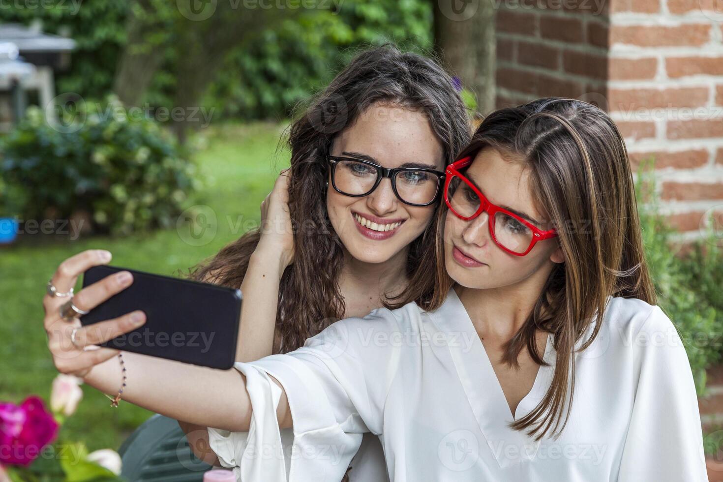 two female young friends take a selfie hugged together photo