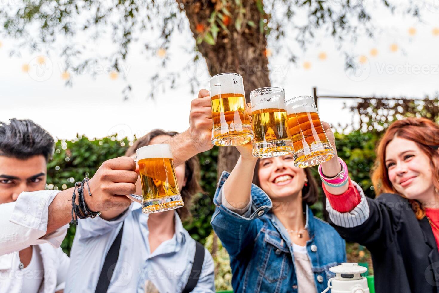 grupo de amigos teniendo divertido a jardín hogar fiesta - joven personas sonriente juntos Bebiendo cerveza foto