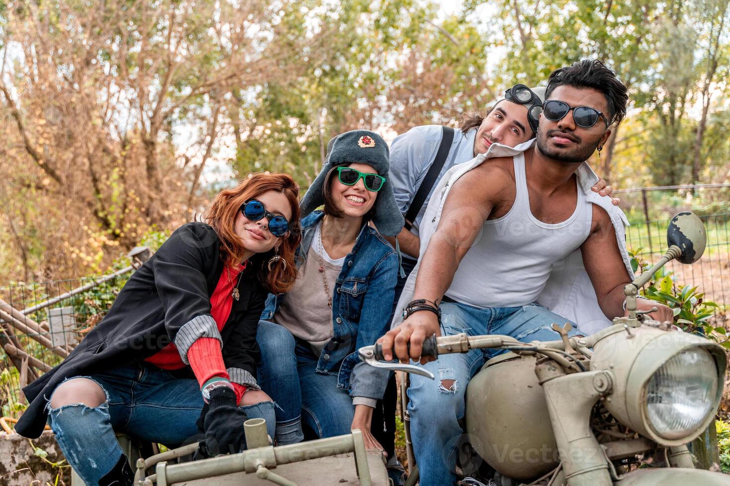 group of best friends together have fun riding a vintage motorcycle with sidecar photo
