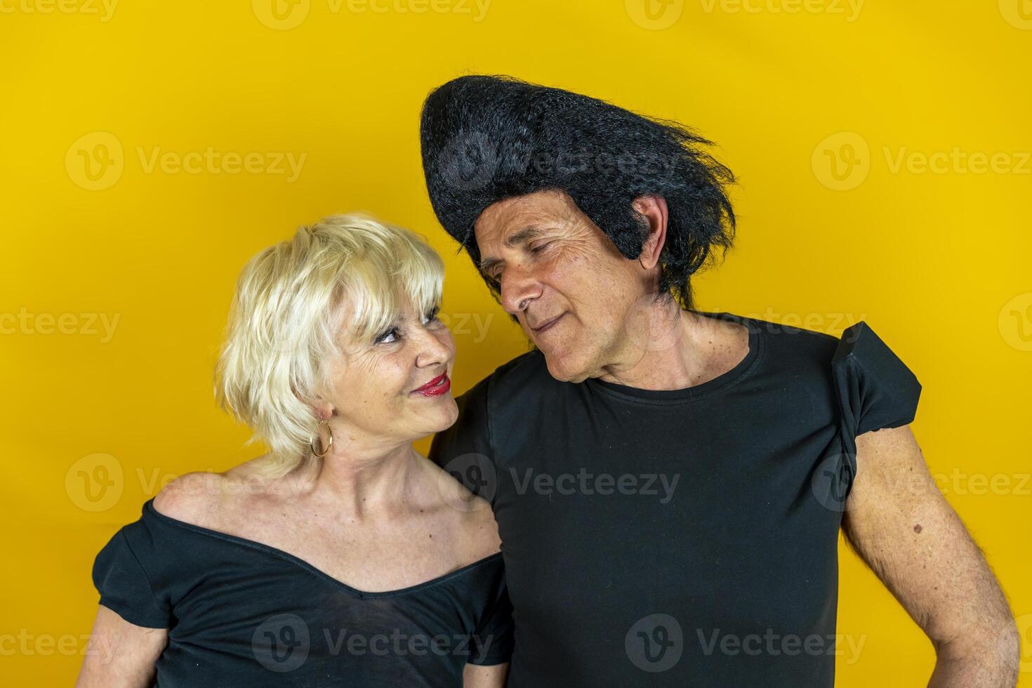 attractive elderly couple dressed in 50's style isolated on colorful background photo
