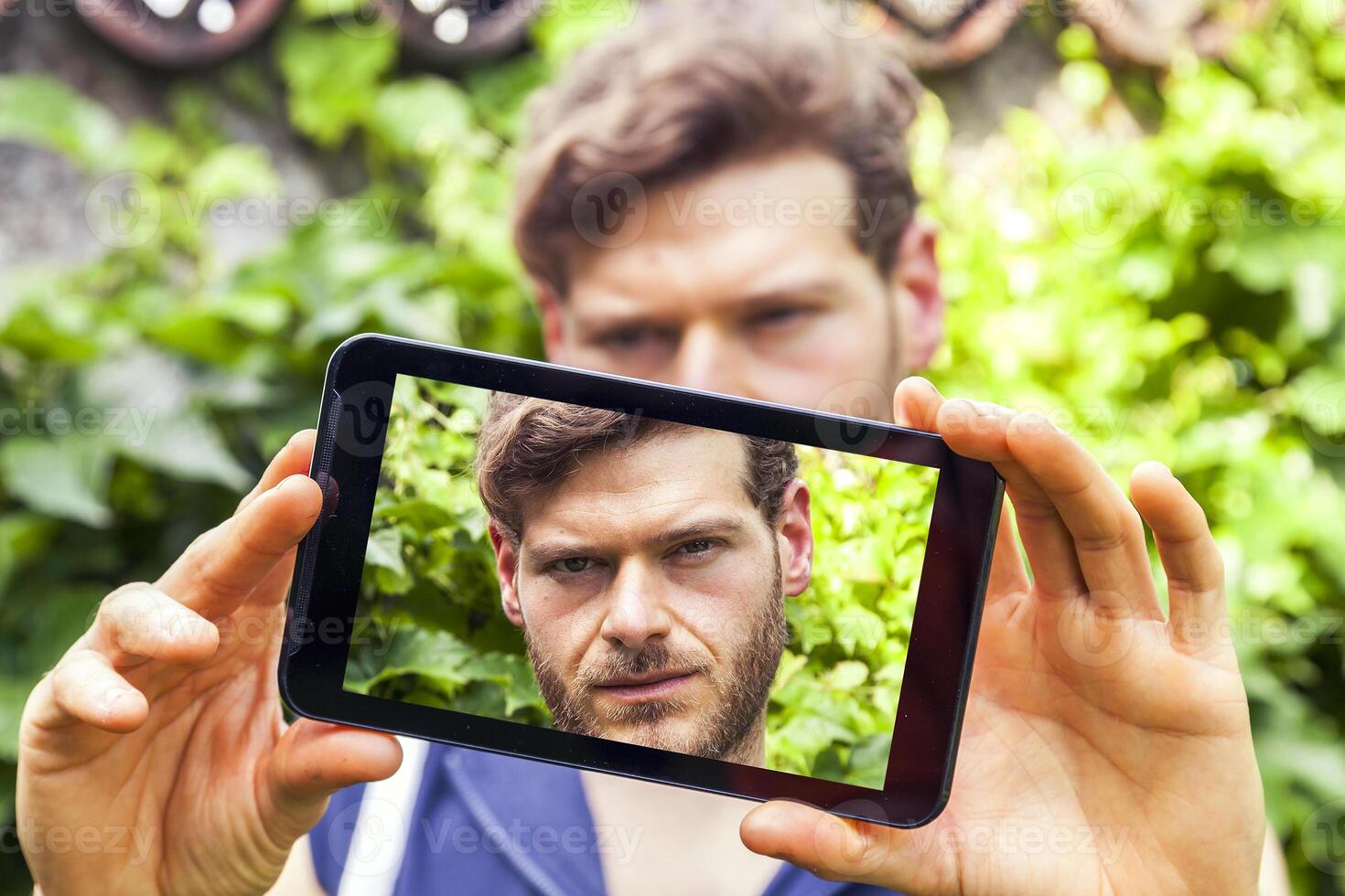 joven milenario hombre tomando un selfie con inteligente teléfono al aire libre foto