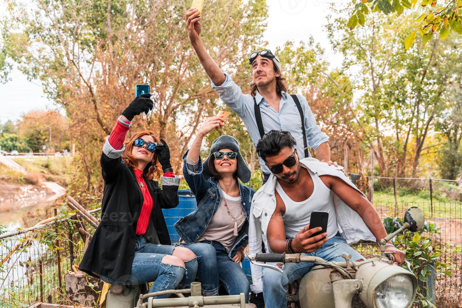 group of best friends take a selfie riding a vintage motorcycle with sidecar photo