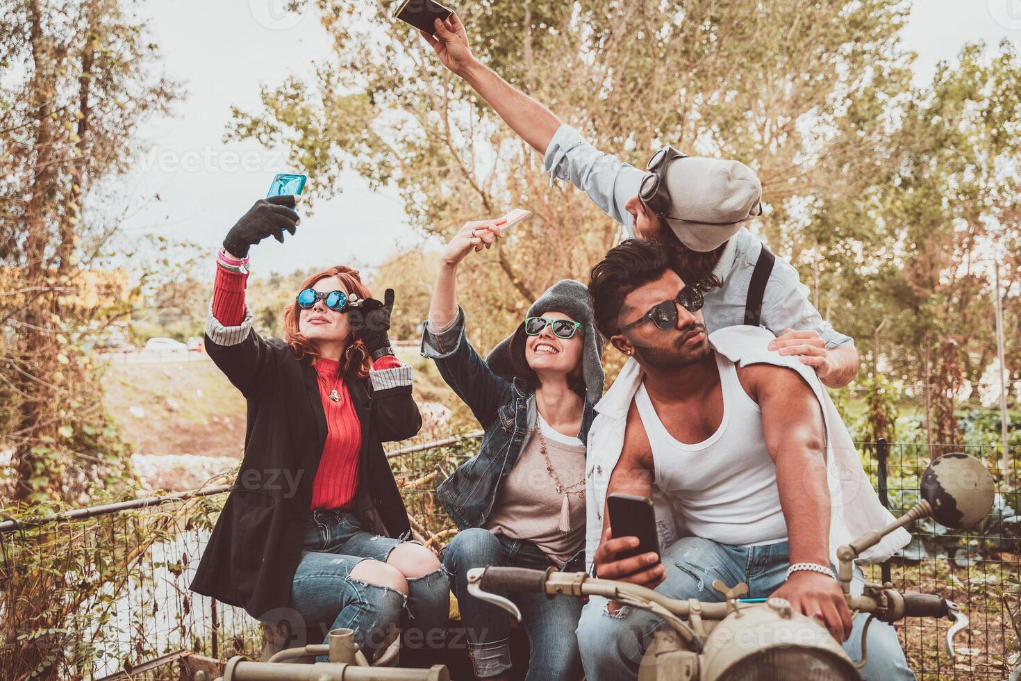 group of best friends take a selfie riding a vintage motorcycle with sidecar photo