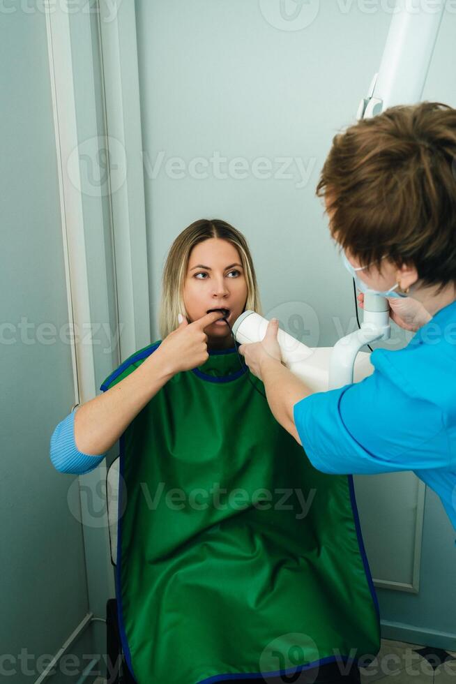 ellos tomar un imagen de el niña en el radiografía dental oficina en el hospital foto