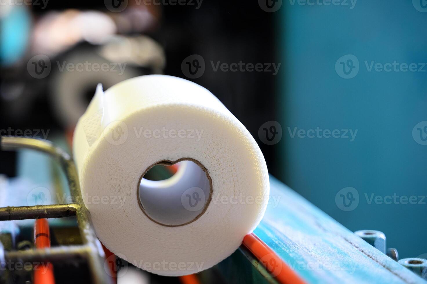 Toilet paper rolls moving along the conveyor belt. Old Greek factory for the production of paper rolls for hygiene. Manufacture of paper towels and toilet paper. Close up view. Selective focus photo