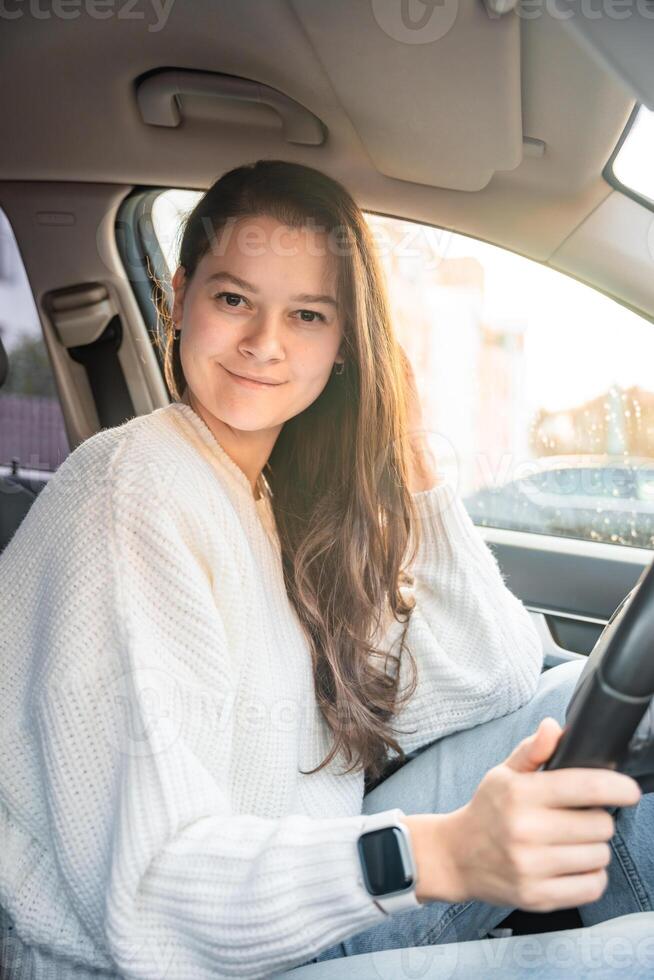 Portrait of young woman inside car interior. The car as a place in which a significant part of people lives passes photo