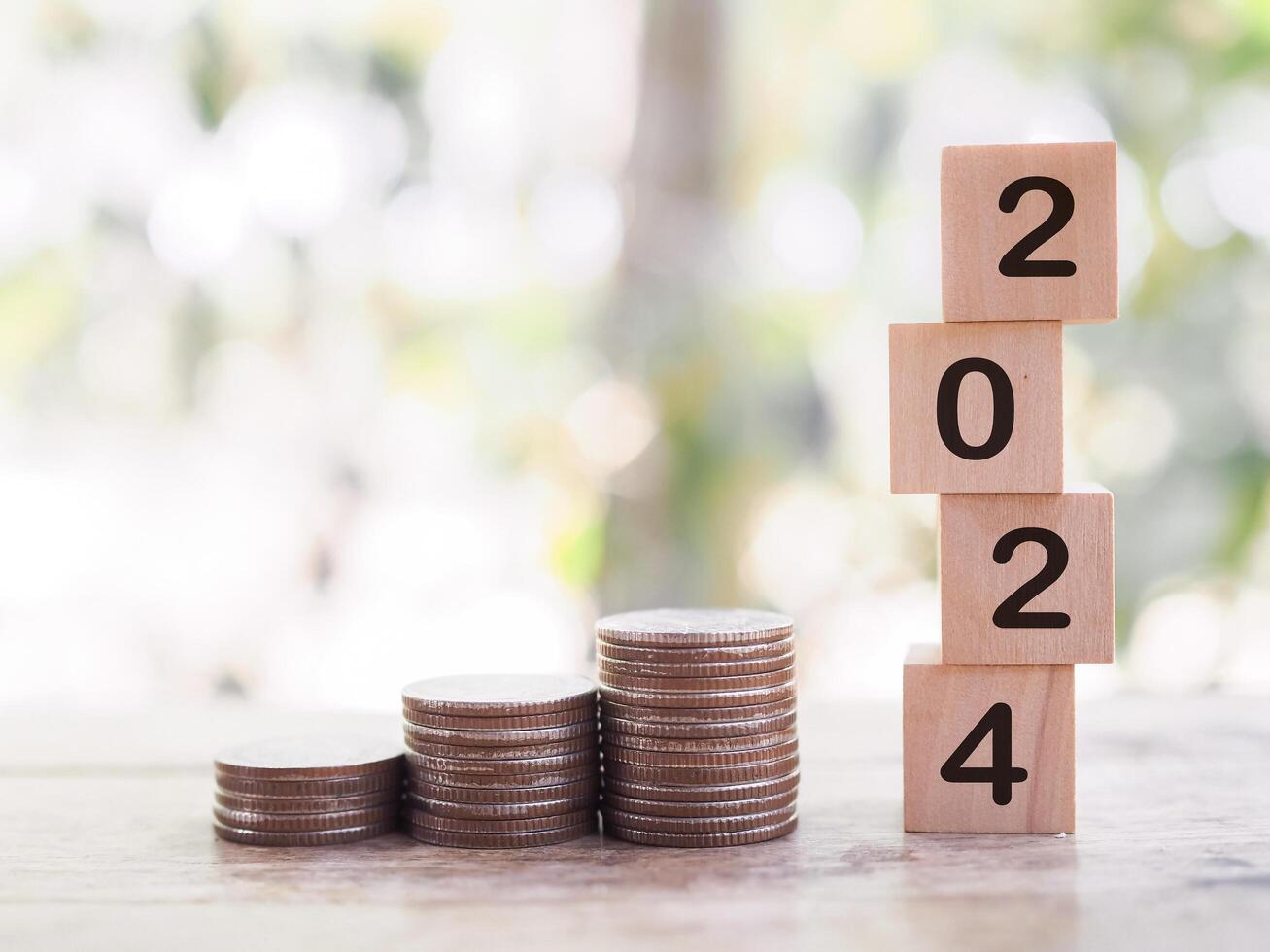 Wooden blocks with the number 2024 and stack of coins. The concept of saving money, Financial, Investment and Business growing in year 2024. photo