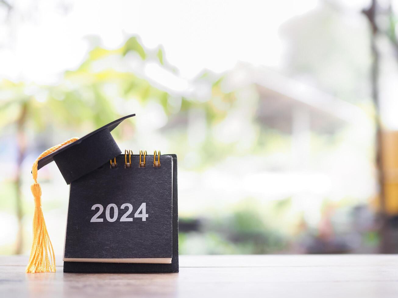 Study goals, 2024 Desk calendar with graduation hat. The concept for Resolution, Goal, Action, Planning, and manage time to success graduate. photo