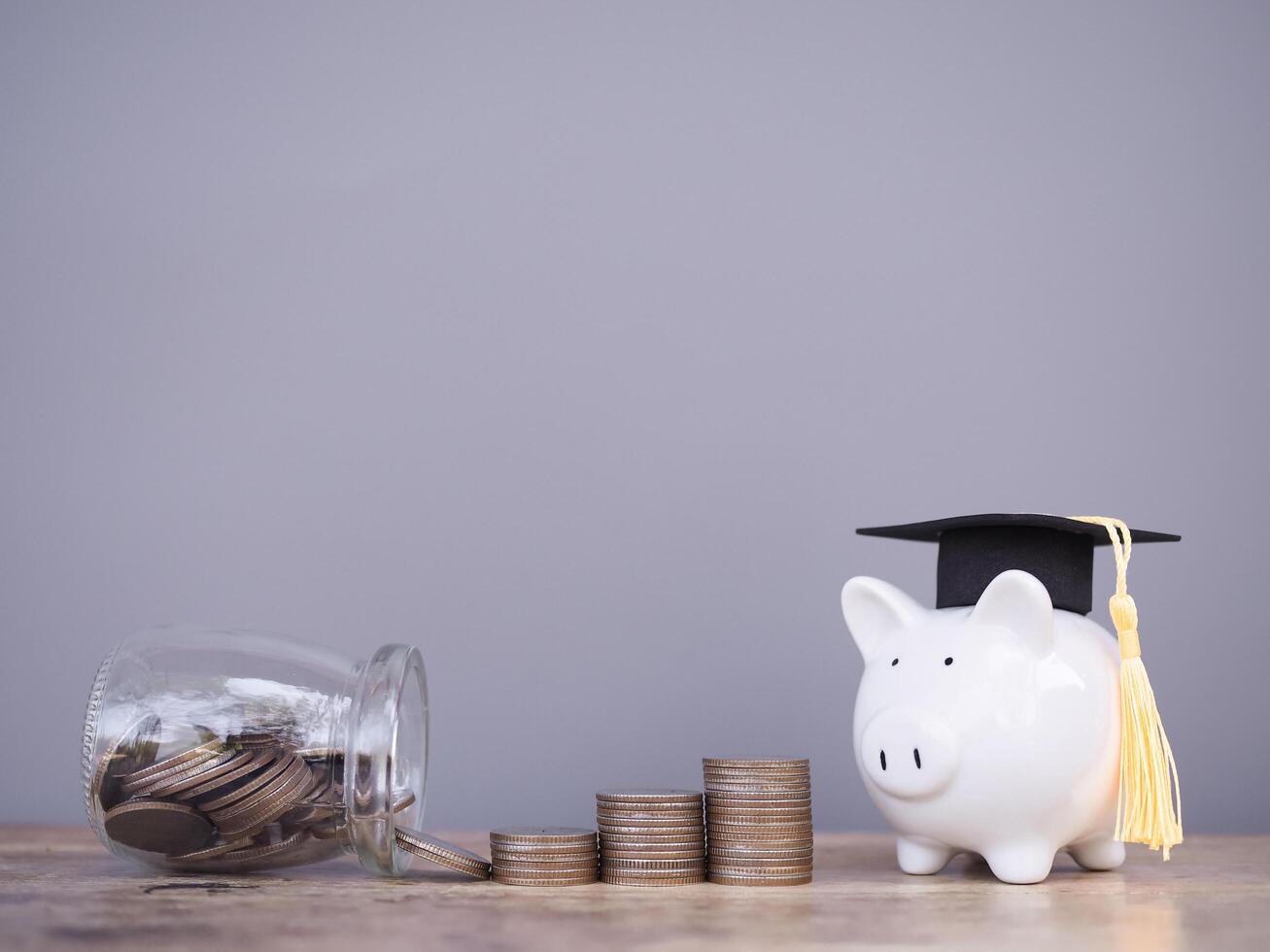 Piggy bank with graduation hat and stack of coins. The concept of saving money for education, student loan, scholarship, tuition fees in the future photo