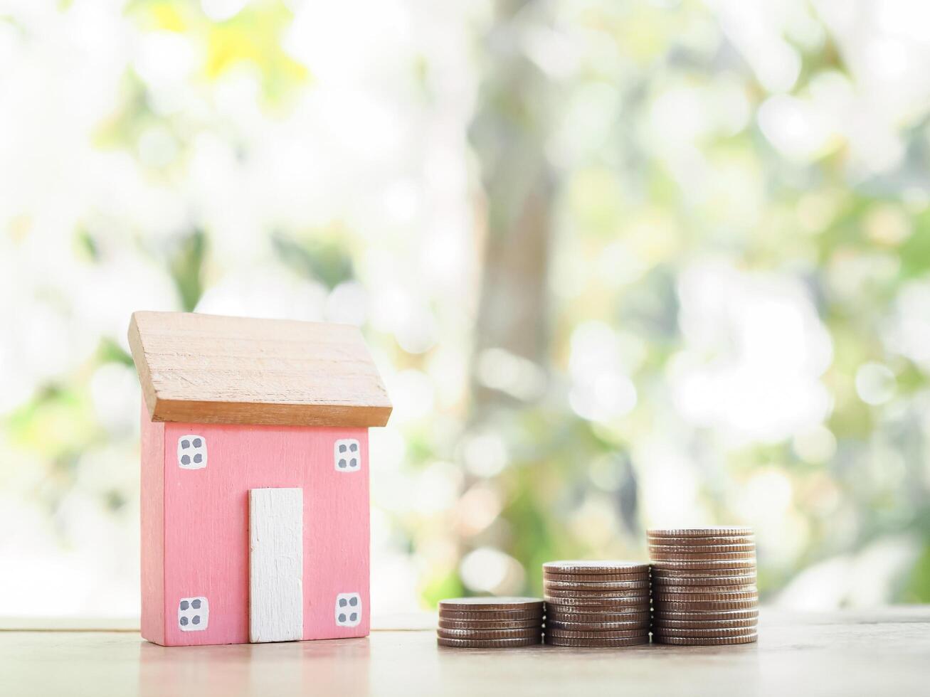 Miniature house and stack of coins. The concept of saving money for house, Property investment, House mortgage, Real estate photo