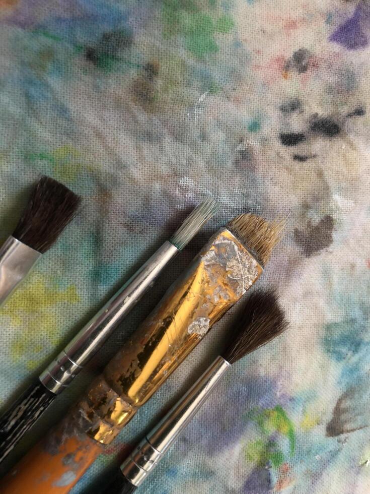 art brushes on spotted canvas, close-up photo