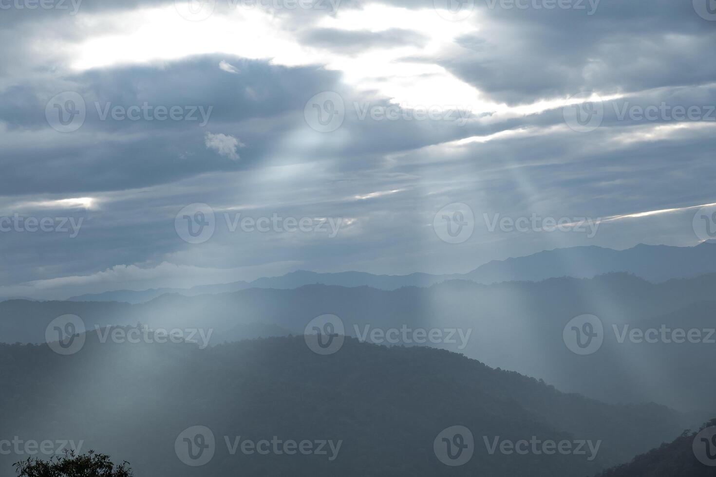 Sun rays filter through the clouds in hills of the valley illuminated by the sun's rays filtering through the clouds photo