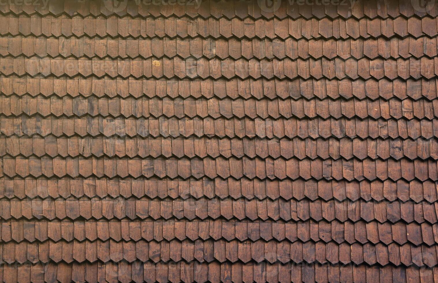 Gray wooden roof tiles background texture. A close up of old gray roof covered with wooden tiles photo