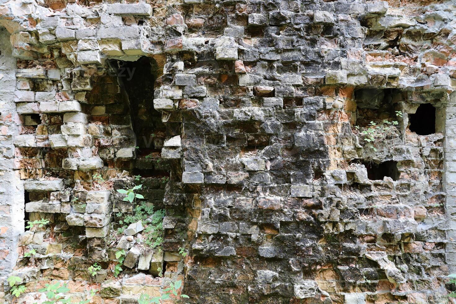 Very old brick stone wall of castle or fortress of 18th century. Full frame wall with obsolete dirty and cracked bricks photo