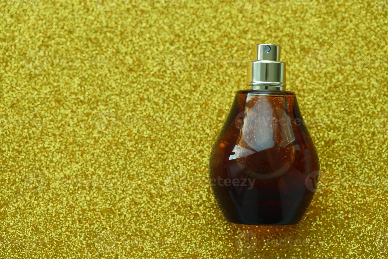 Women fragrance perfume bottle on yellow background close up. Unnamed blank sprayer bottle of perfume photo