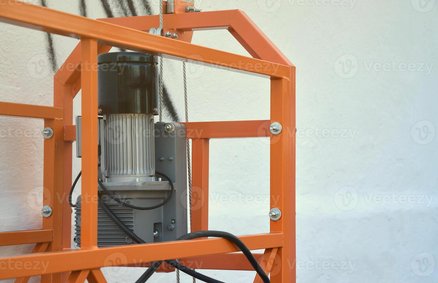 Hoist supply and safety lock as part of suspended wire rope platform for facade works on high multistorey buildings. Hoist for elevation, raising or lifting cradle photo