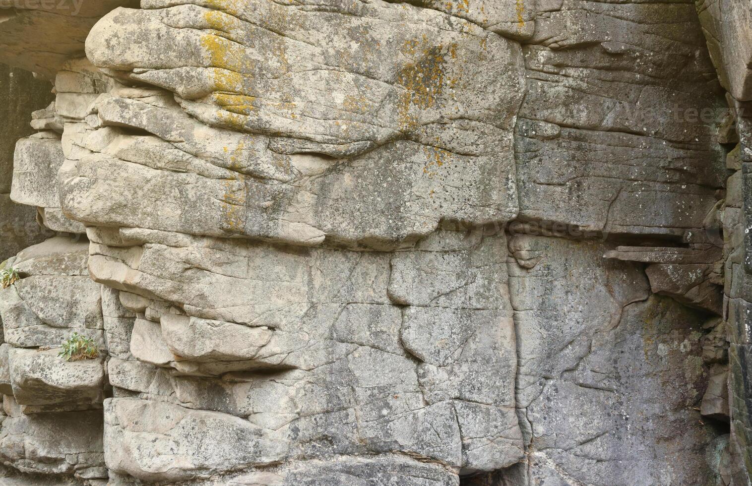 Light coarse natural rock stone background. Mining cliff rough front surface. Big limestone stack backdrop. Heavy grunge damaged granite block texture photo