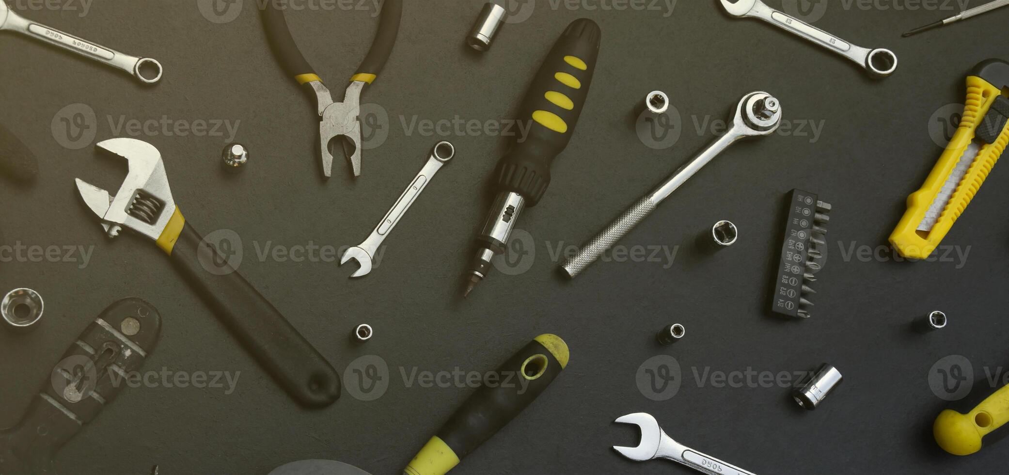 Handyman tool kit on black wooden table. Many wrenches and screwdrivers, pilers and other tools for any types of repair or construction works. Repairman tools photo