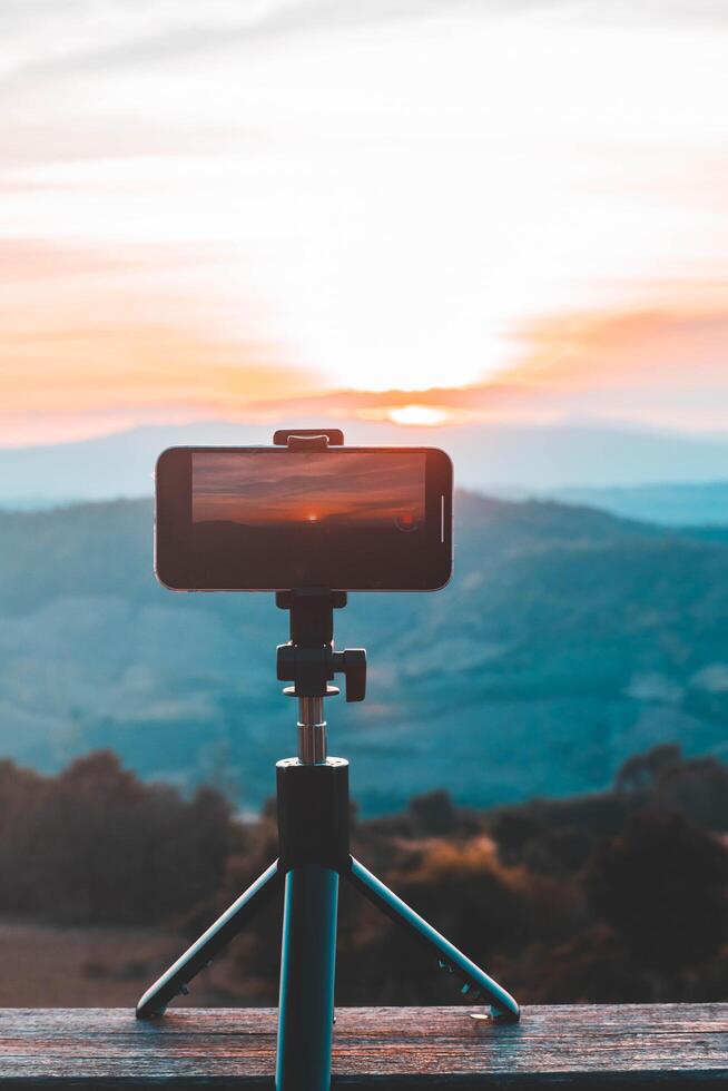 A smartphone is recording the sun setting over a mountain range. photo