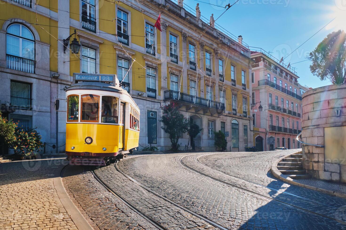 Famous vintage yellow tram 28 in the narrow streets of Alfama district in Lisbon, Portugal photo