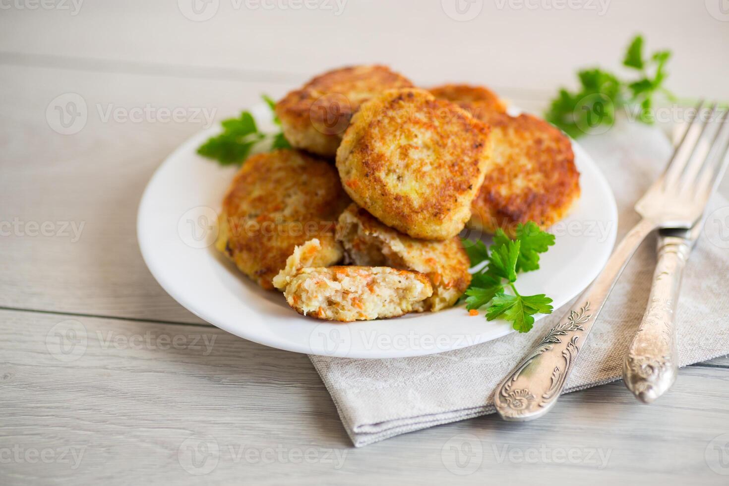 Cooked fried fish cutlets in a plate with herbs. photo