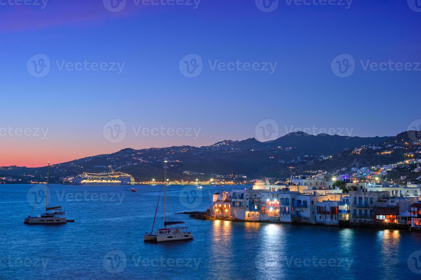 Sunset in Mykonos, Greece, with cruise ship and yachts in the harbor photo