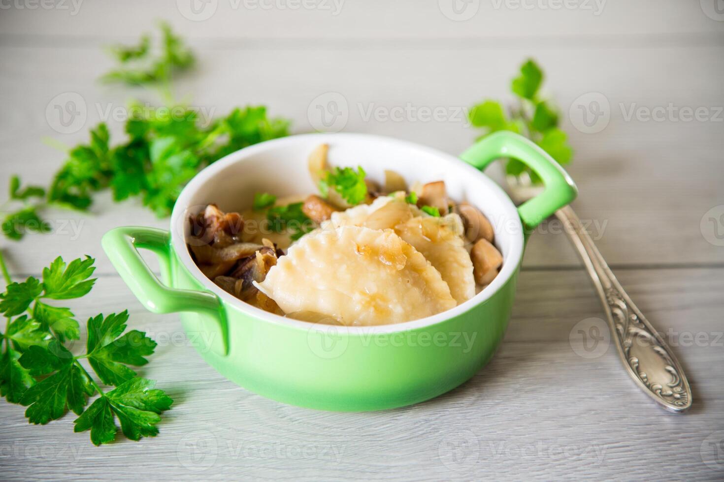 Potato dumplings with onion and mushrooms in a plate. photo