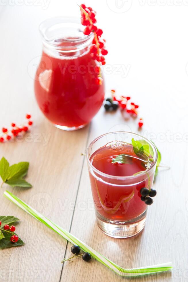 fresh berry juice from red and black currant, on a wooden table photo