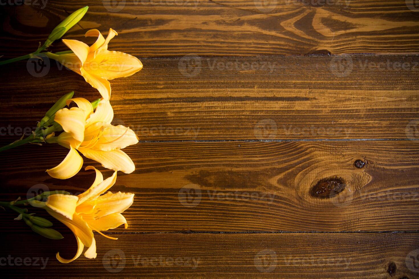 bouquet of beautiful yellow lilies on wooden table photo