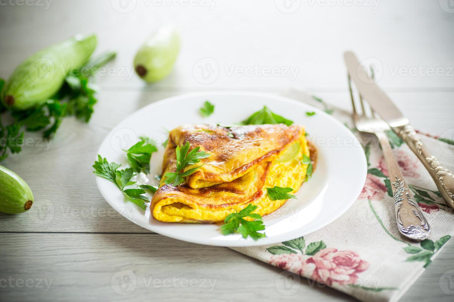 Fried omelet with zucchini, on a wooden table. photo