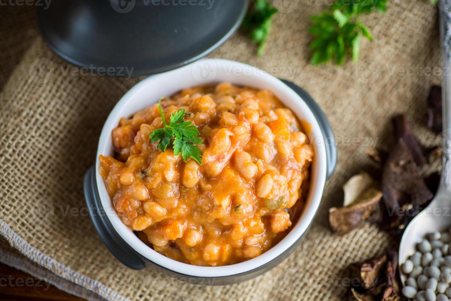 beans stewed with vegetables and spices, in a bowl . photo