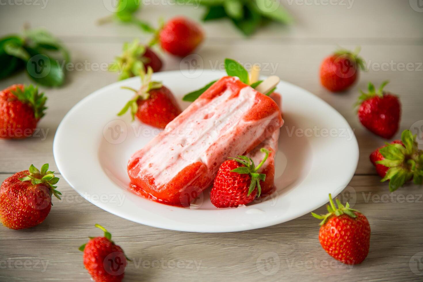 homemade strawberry ice cream on a stick in a plate with strawberries photo