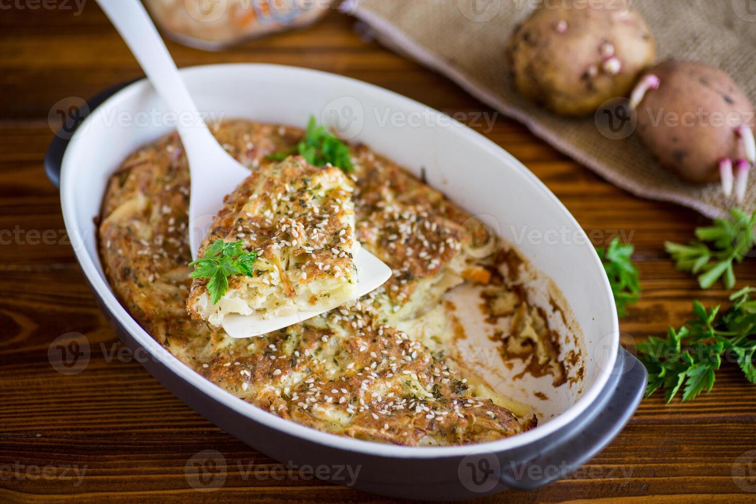 potato casserole with cabbage and spices in a ceramic form photo