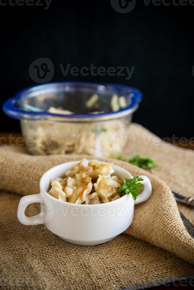 cooked dumplings with potatoes and fried onions on a wooden table. photo