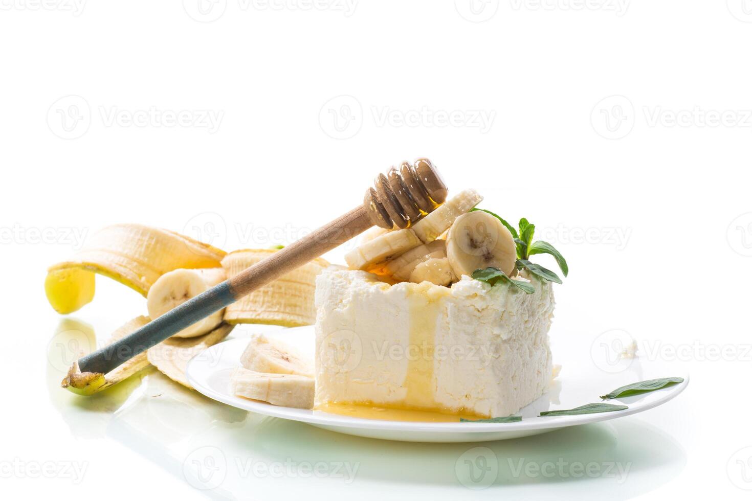 Portion of homemade milk curd with banana slices and honey photo