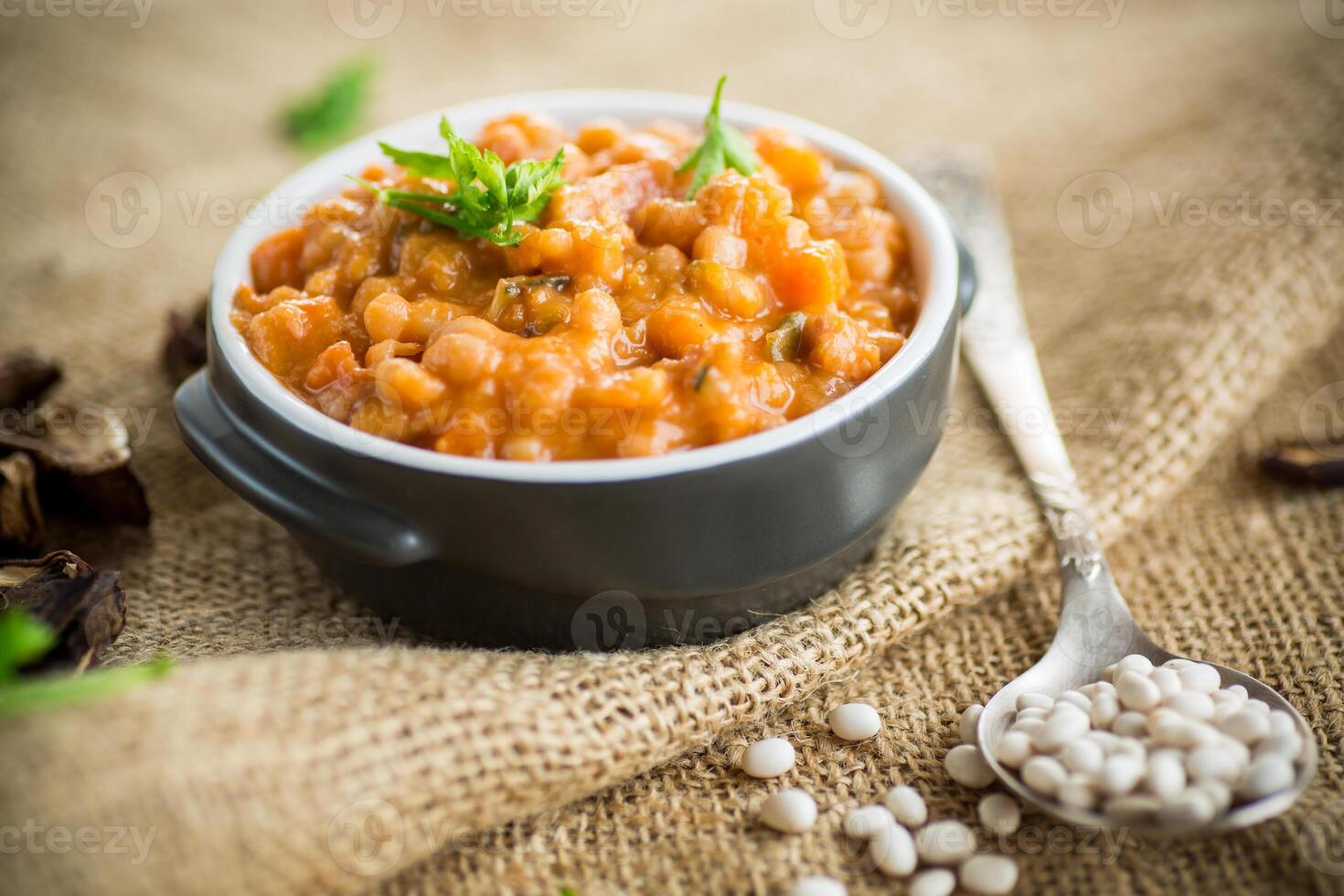 beans stewed with vegetables and spices, in a bowl . photo