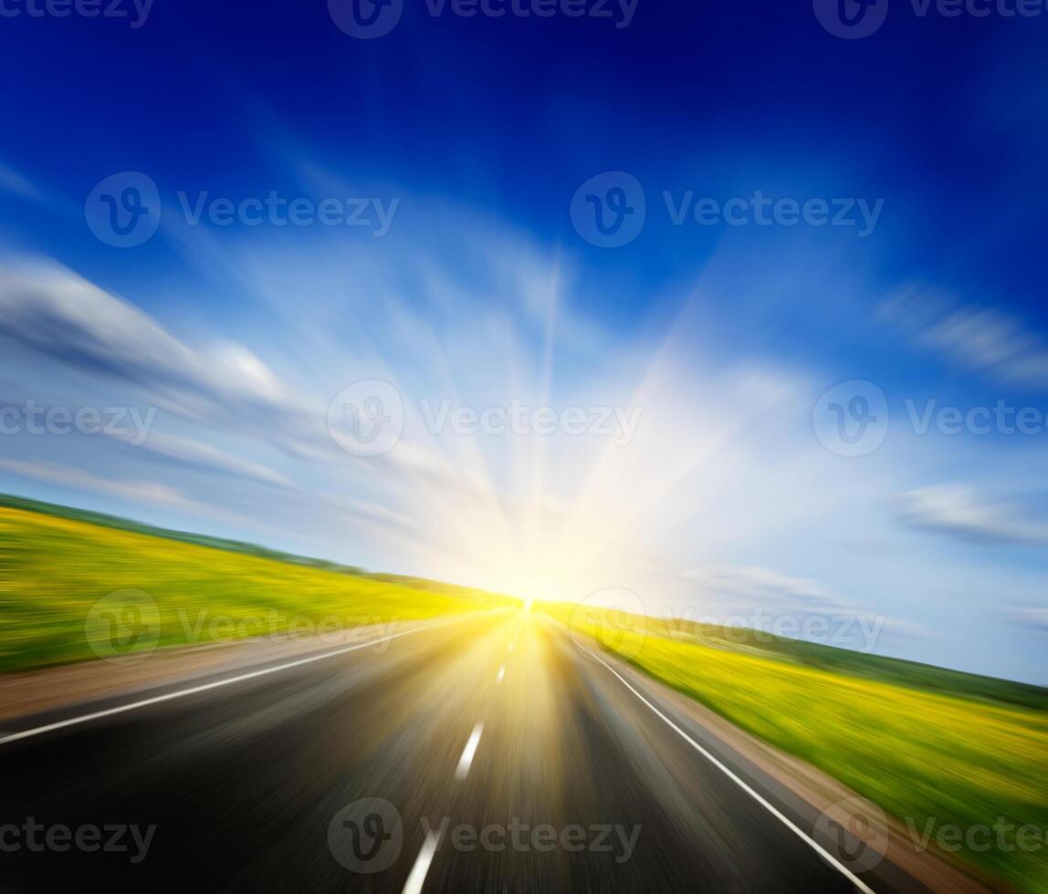 Motion blurred road in blooming spring meadow photo