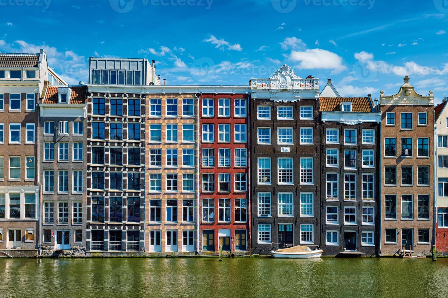 houses and boat on Amsterdam canal Damrak with reflection. Ams photo