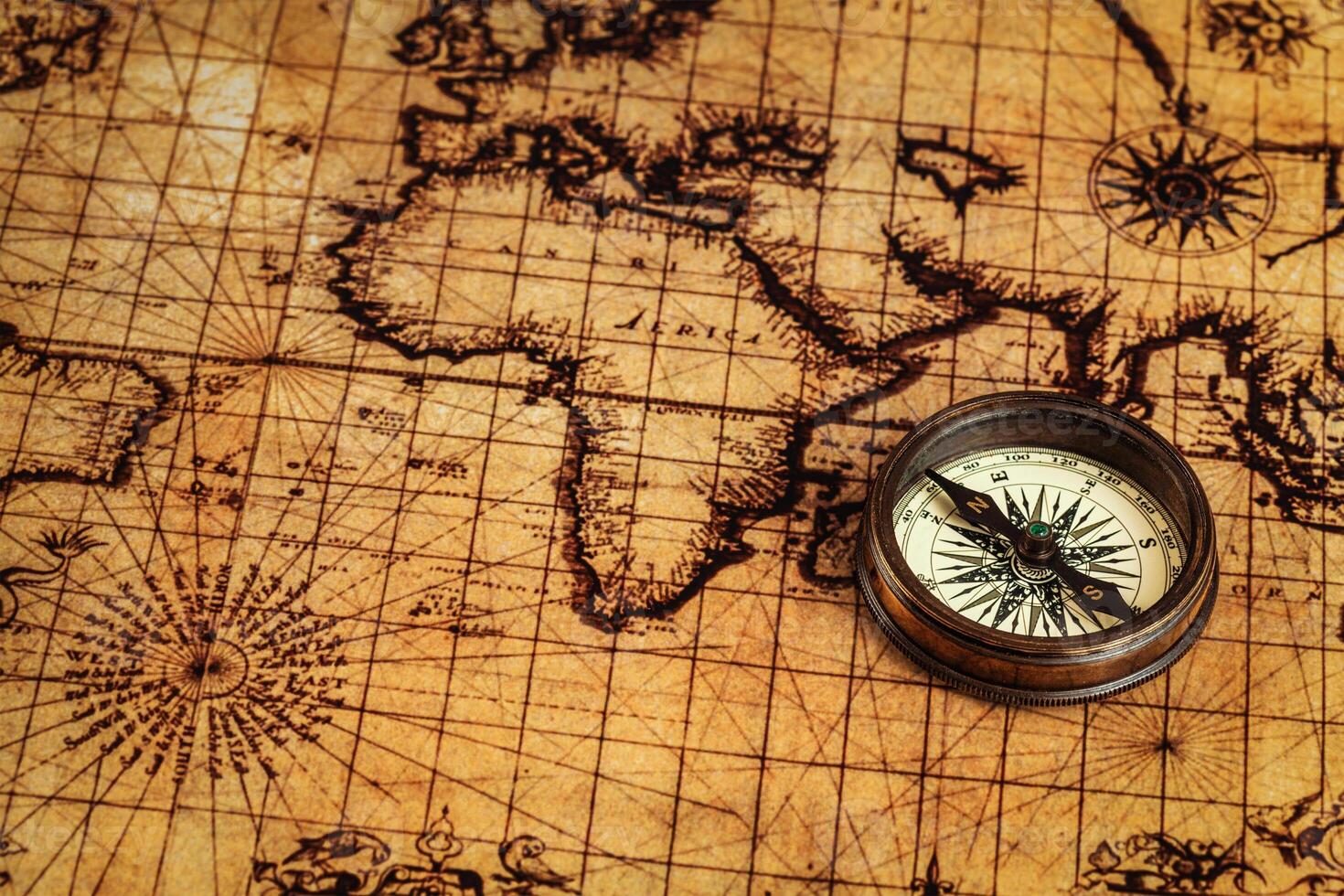 Old vintage compass on ancient map photo