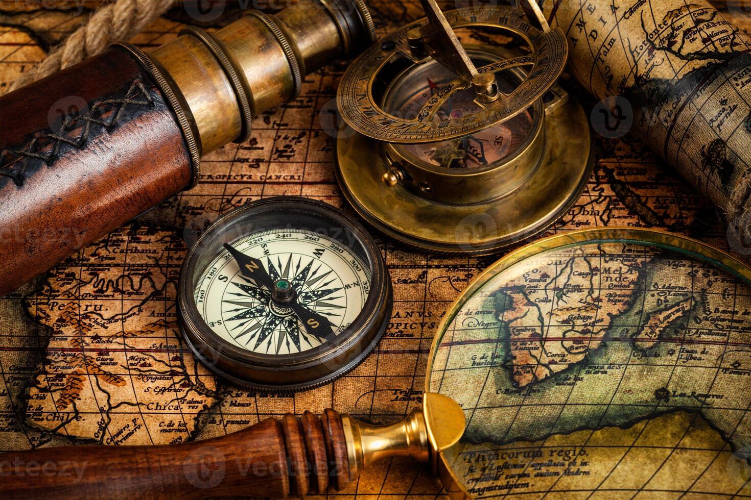 Old vintage compass and travel instruments on ancient map photo