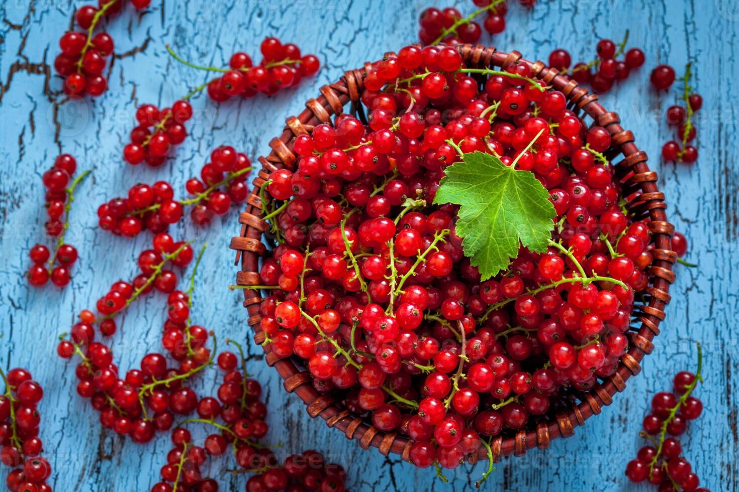 Redcurrant in wicker bowl on the table photo