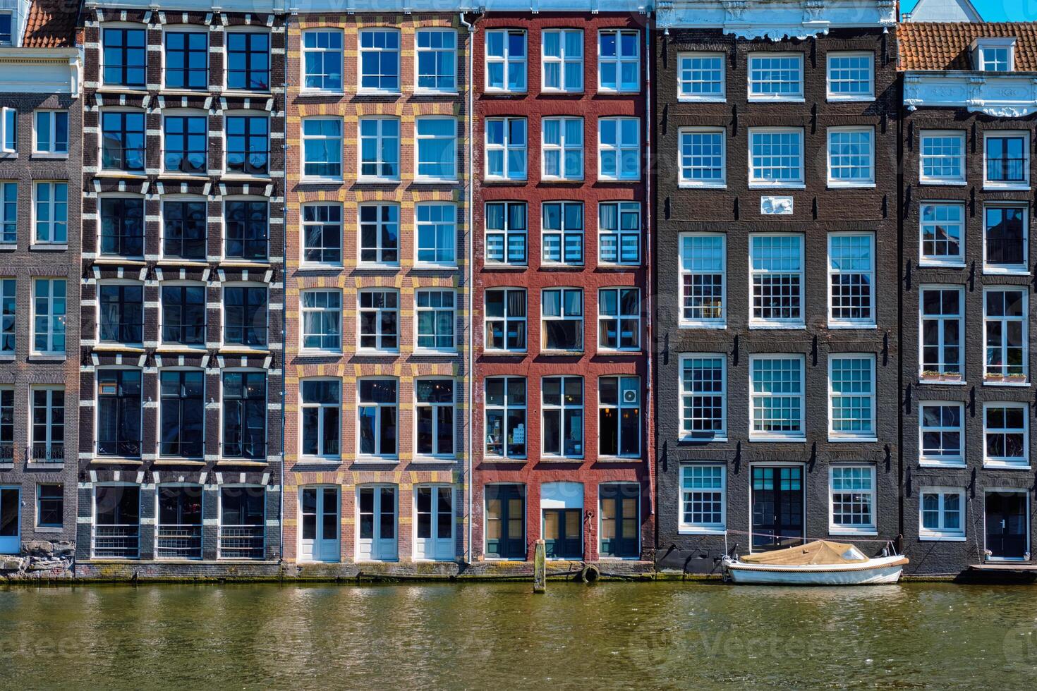 casas y barco en Amsterdam canal Damrak con reflexión. ams foto