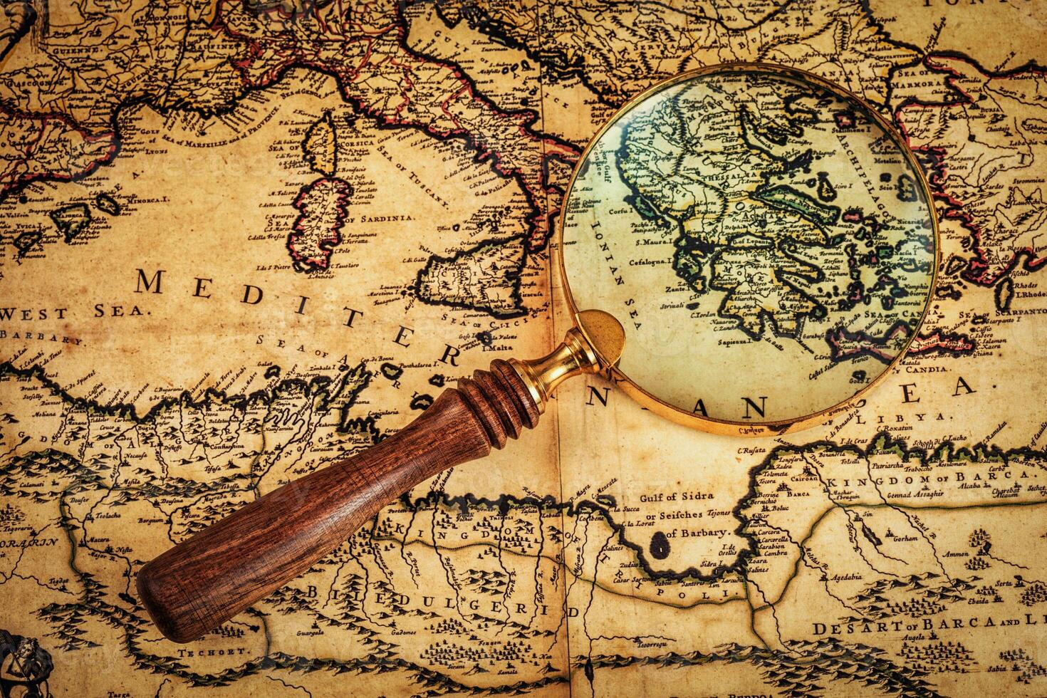 Old vintage magnifying glass on ancient map photo