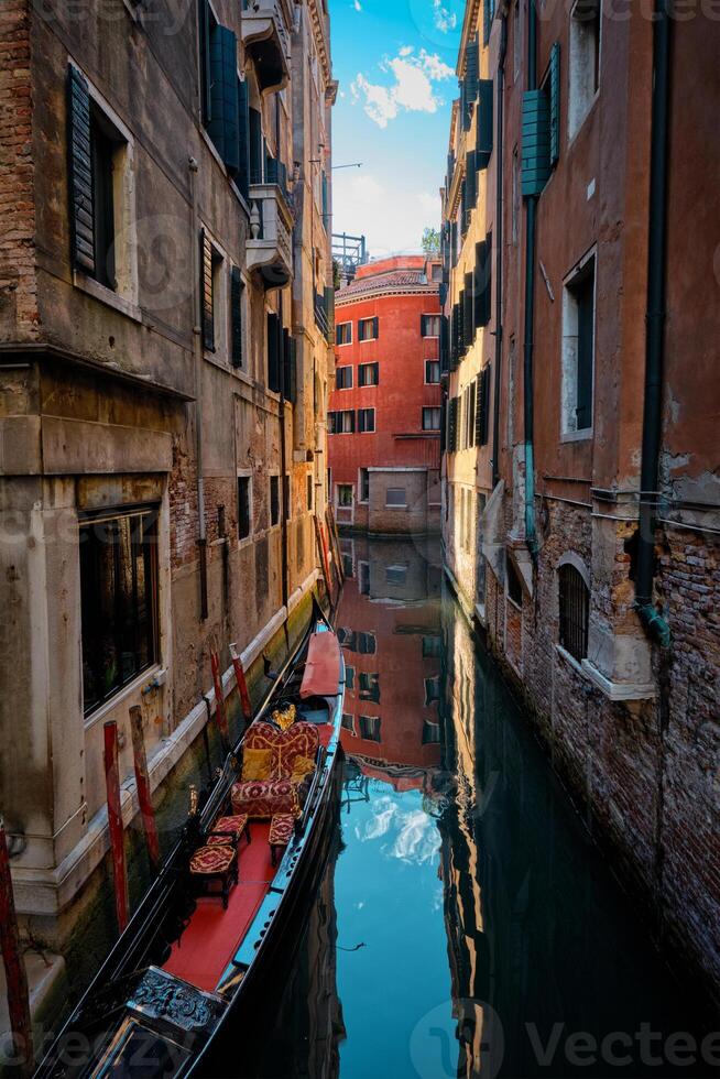 Narrow canal with gondola in Venice, Italy photo