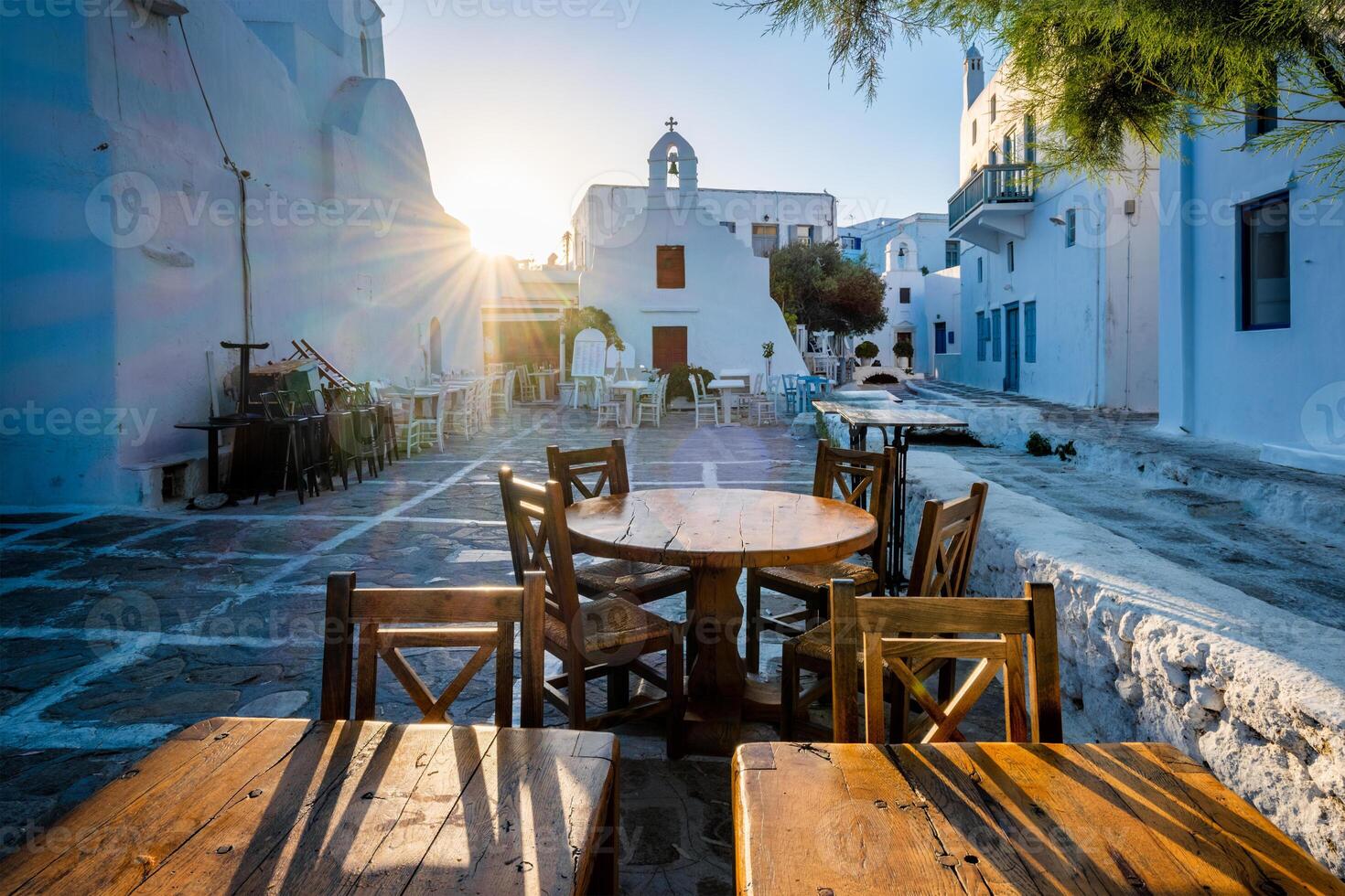 Cafe table in picturesque streets of Mykonos Chora town in famous tourist Mykonos island, Greece photo