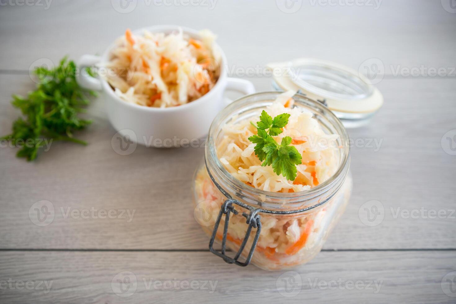Sauerkraut with carrots and spices in a glass jar photo
