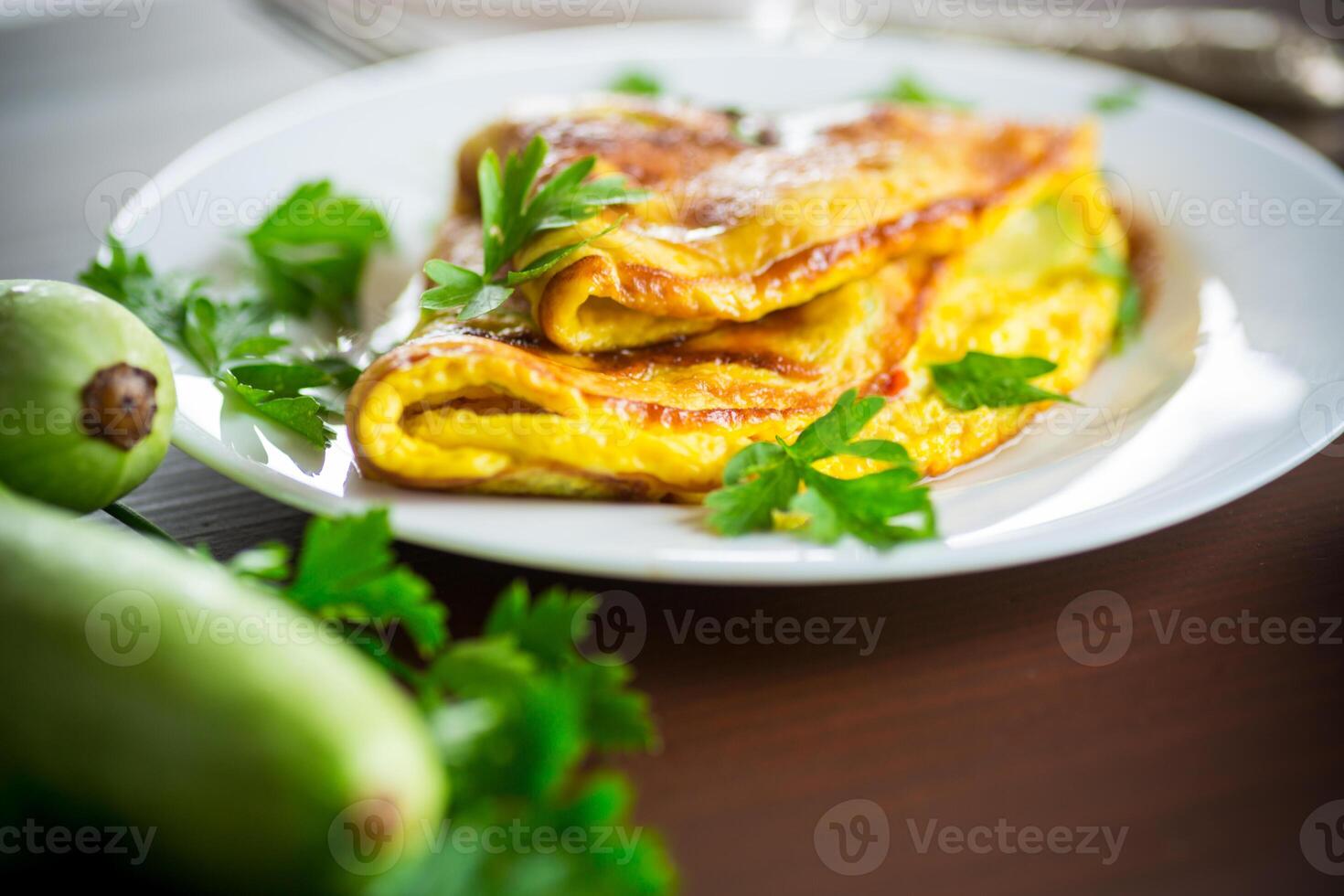 Fried omelet with zucchini, on a wooden table. photo